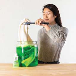 Rit All Purpose Liquid Dye - Neon Green, 8 oz, adult submerging sweater in dyed water