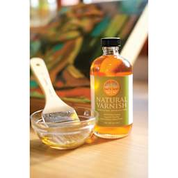 Natural Earth Paint Natural Varnish - Glass Bottle next to brush in cup of varnish
