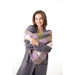 Lion Brand Basic Stitch Anti-Microbial Yarn, adult wearing blanket made with yarn
