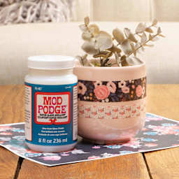 Floral pattern paper adhered to plant pot and sealed with Plaid Mod Podge Super Gloss Finish
