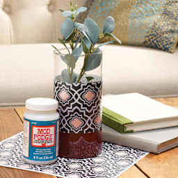 Jar of Mod Podge next to decorated plant pot sealed with Super Gloss Finish