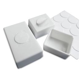 Adhesive dots used to hold the pans in place