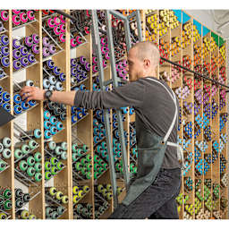 Individual stocking shelves wearing the Blick Utility Apron