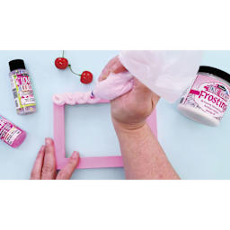 DecoArt Love Color Frosting Acrylic being used with an icing bag and frosting tip.