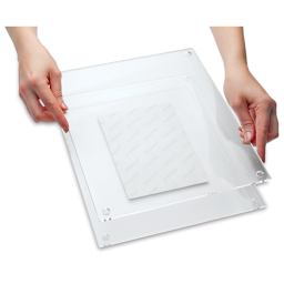 Wexel Art Double Panel Acrylic Display Frame - 28" x 40", hands assembling frame