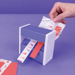 Xyron Sticker Maker, sticker sheet being fed