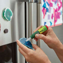 Krazy Glue All Purpose Super Glue - Hands using Pen to glue Polished Stone to metal