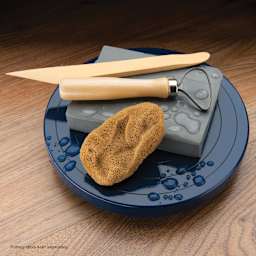 Royal & Langnickel Elephant Ear Sponge - 3 to 3-1/2" with other pottery supplies on a banding wheel