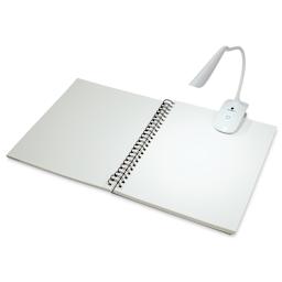 Daylight Smart Clip-On Lamp on open sketchbook in lit space