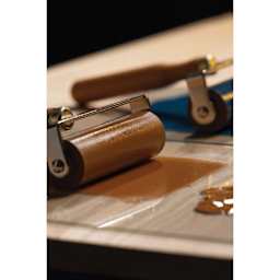 Pebeo Lino Ink - Natural Sienna, 80 ml Tube being applied to glass plate with brayer