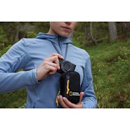 National Geographic Camera Pouch, in hand removing camera (not included) from the top of the pouch