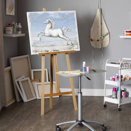 Studio Designs Museum Easel - Natural Finish, canvas on the easel stationed inside a studio