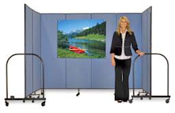 Screenflex Portable Room Dividers - Woman standing in front of 7 panel Blue Divider