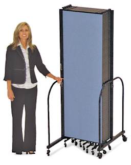 Screenflex Portable Room Dividers - Woman standing with folded Blue Divider