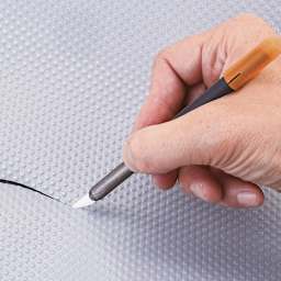 Slice Ceramic Craft Knife - Closeup of knife cutting through plastic
