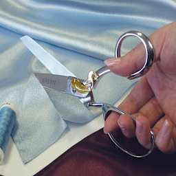 Gingher Dressmaker's Shears - Hand shown using shears to cut blue fabric