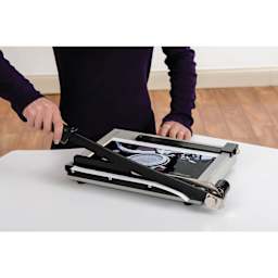 Dahle Paper Trimmer - 12" Cutting Length, 19-3/4" x 10-1/4", person using trimmer to cut a photo
