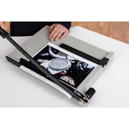Dahle Paper Trimmer - 15" Cutting Length, person cutting a photo using spring action blade