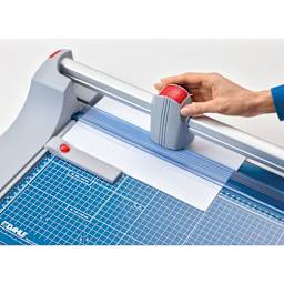 Dahle Premium Rotary Trimmer, adult hand pulling blade across paper