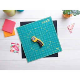 Olfa Rotating Cutting Mat - 17" x 17" - demonstration of the non-slipping and self-healing mat rotated, with craft supplies