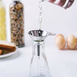 Fox Run Stainless Steel Funnel Set - Set of 3 funneling fluid into flask