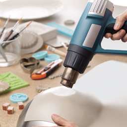 Thibra Fine Sculptable Plastic - Person making plastic pliable with Heat Gun