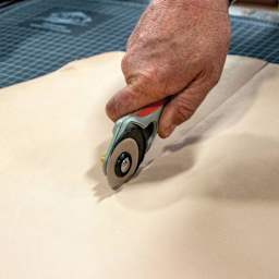 Realeather Veg-Tan Double Shoulder Leather, being cut by a razor in hand