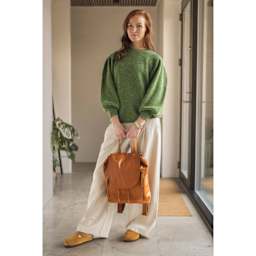 Muud Gimo Leather Backpack - Brown - model holding bag by handle