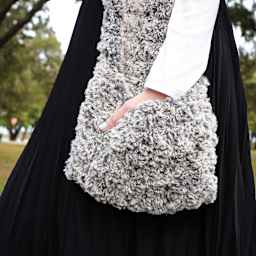 Lion Brand Go For Faux Thick And Quick Yarn - Side view of model carrying finished Knit Bag