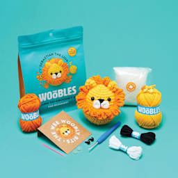 The Woobles Beginner Crochet Amigurumi Kit - Lion, contents and finished project laid out