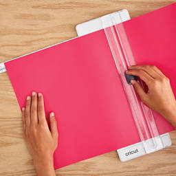 Cricut Portable Trimmer - Trimmer shown in use cutting Red paper