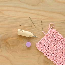 Boye Wood Container & Yarn Needles - Pkg of 6 Needles, Lilac Lid - in use, next to pink knitting example