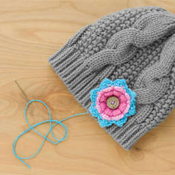 Boye Wood Container & Yarn Needles - Pkg of 6 Needles, Coral Lid - in use, next to knit beanie example