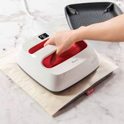 Cricut EasyPress 2 - Raspberry, 9" x 9", hand holding down press on top of fabric