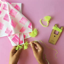 Loome Fiber Craft Tools - Hands sewing tiny pompoms onto material 