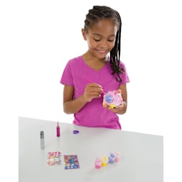 Created by Me Banks - Child at table with paints, holding and painting Piggy Bank