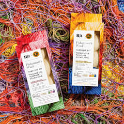 Lion Brand x Rit Fishermen's Wool Yarn Dye Kits on pile of dyed yarn, close-up