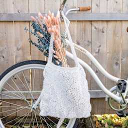 Lion Brand Stitch Soak Scrub Yarn - Coconut Milk finished tote bag hanging off bike handlebar