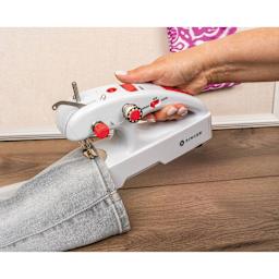 Singer Stitch Quick Plus Handheld Mending Machine, being held and sewing seam