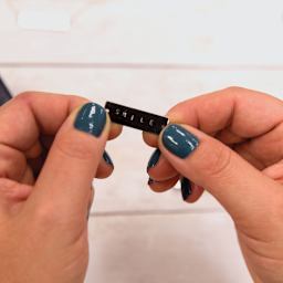 STMT Hand-Stamped Jewelry Kit (Person holding stamped rectangle blank)