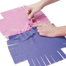 Melissa & Doug Created by Me Flower Fleece Quilt - Hands feeding one piece through slot of another
