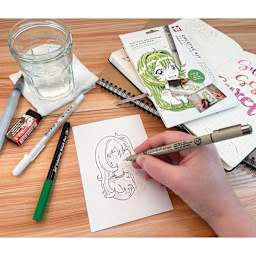 Sakura Creative Kit - Manga, contents shown on table and Pigma Micron in hand