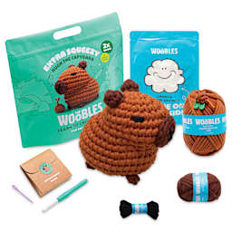 The Woobles Extra Squeezy Crochet Kit - Hugh the Capybara contents with completed project