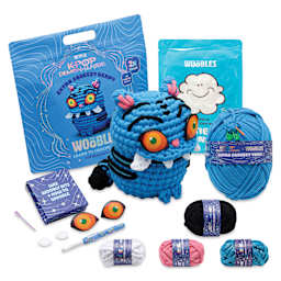 The Woobles Extra Squeezy Crochet Kit - Derpy the Tiger contents with completed project