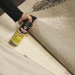 DAP Weldwood Multi-Purpose Spray Adhesive - 11 oz Can being applied to the bottom of a rug