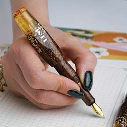 Benu Pixie Fountain Pen - Honey Bronze, pen in hand (image may show a different size nib)