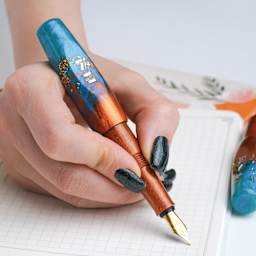 Benu Pixie Fountain Pen - Aurora Gold, pen in hand (image may show a different size nib)
