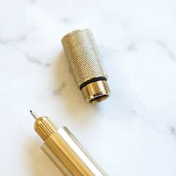 Tom's Studio Lumos Pro Refillable Single Tip Pen - Brass, close-up of the top of the pen