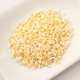 John Bead Cylin 11/0 Cylindrical Seed Beads - Cream AB sitting in dish