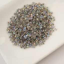 John Bead Cylin 11/0 Glow in the Dark Cylindrical Seed Beads - Grey AB, 25g sitting in dish